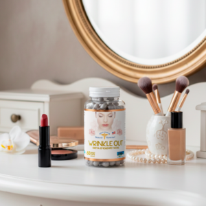 Frasco transparente con etiqueta blanca con dorado y tapa blanca del producto wrinkle out x 60 Twist Caps en una mesa marmolada y al rededor hay maquillaje, espejo, labial, rodillo, mascarilla, brochas